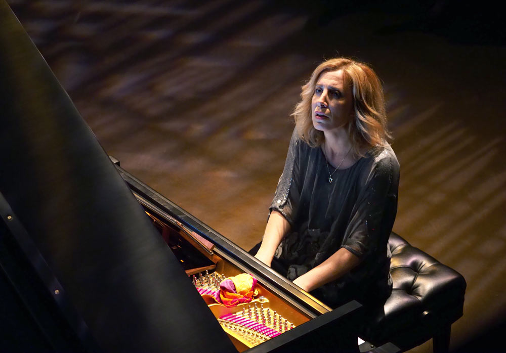 woman playing piano on stage