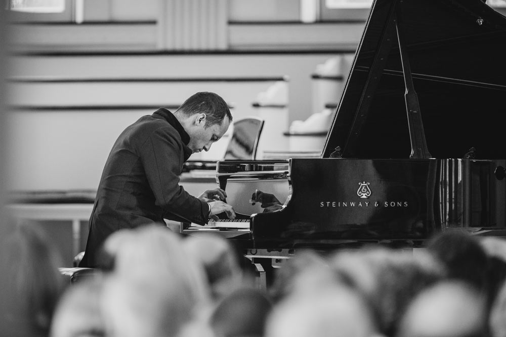Igor Levit playing piano in black and white