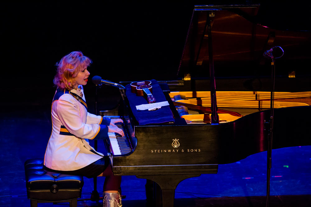 Nellie McKay singing and playing the piano on stage
