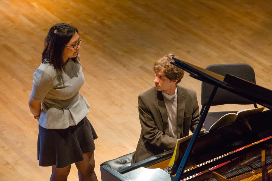 Rafal Blechacz sitting at a piano while talking to a student