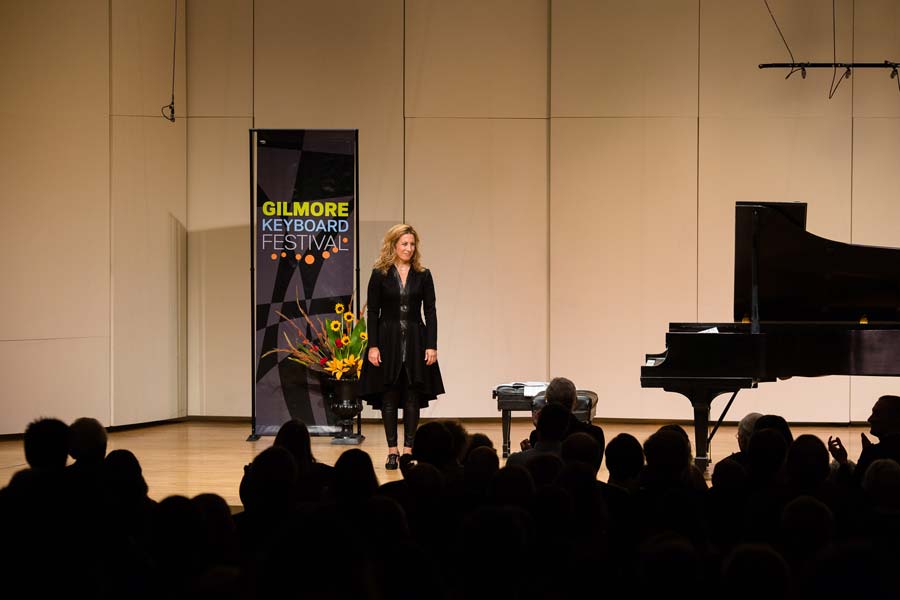 Ingrid Fliter standing on stage beside the piano