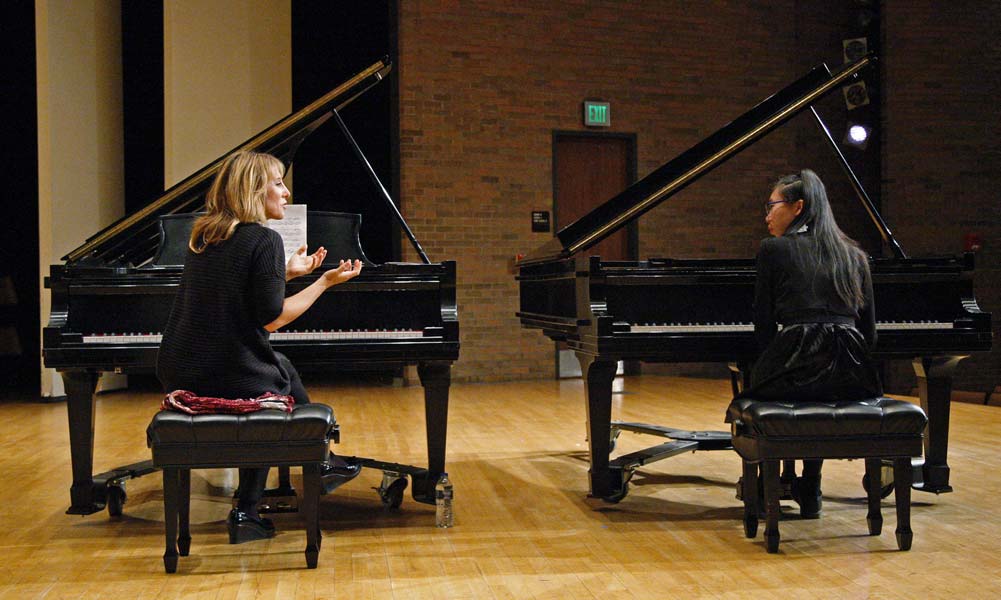 Ingrid Fliter sitting at a piano alongside her student
