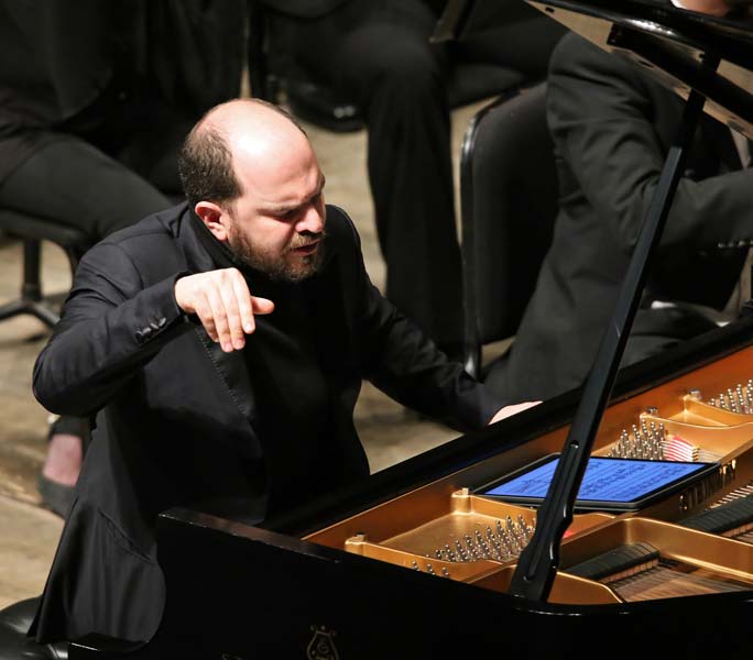 Kirill Gerstein with one hand in the air during his performance