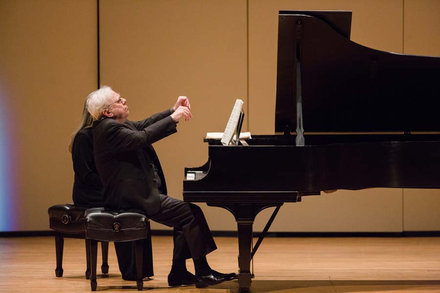 Richard Goode with his hands in the air during a piece