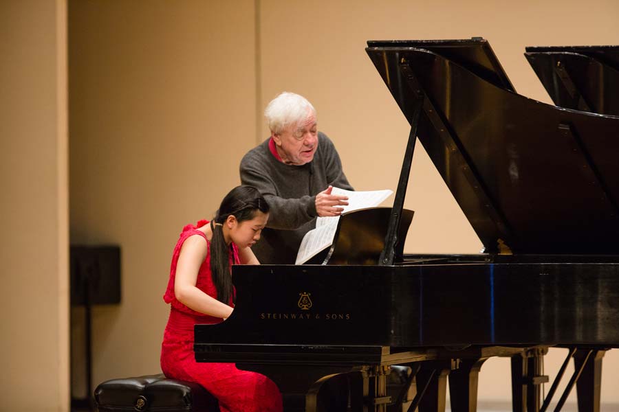 Richard Goode reading music to a student at the piano