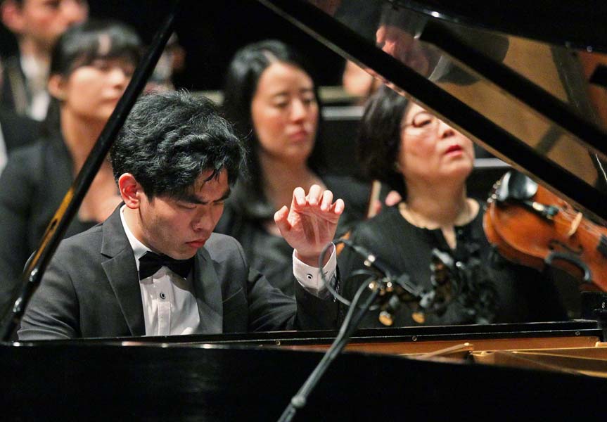 Daniel Hsu with orchestra in the background