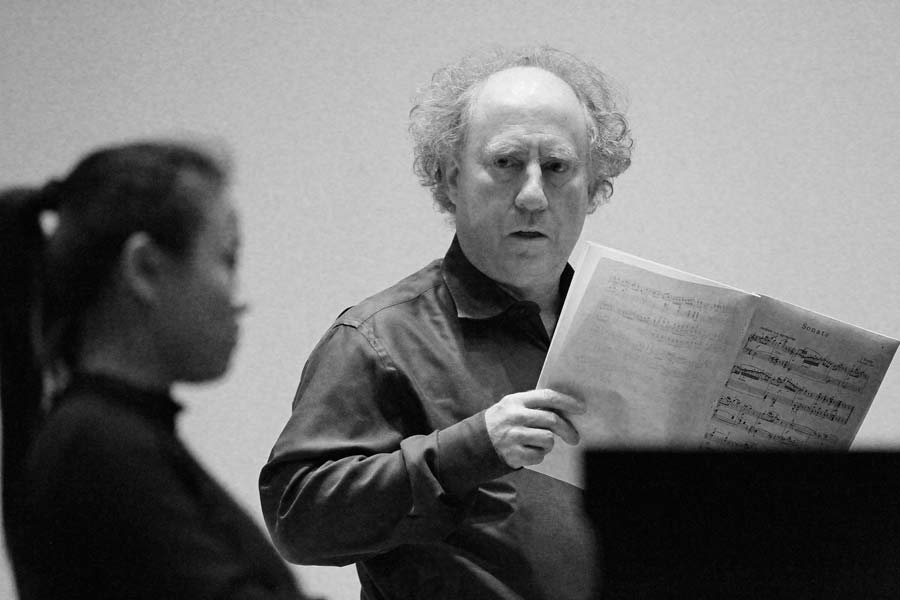 Jeffrey Kahane holding music while looking at student