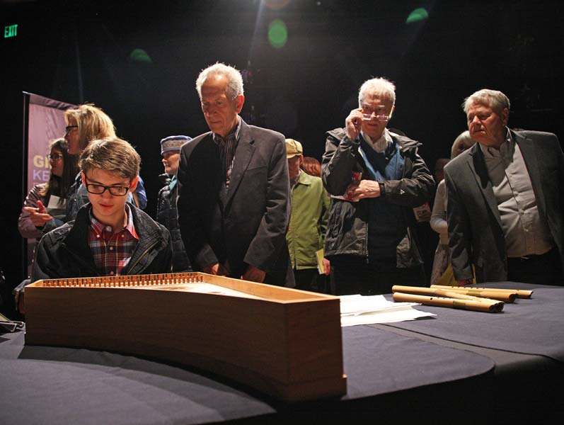 a group looking at Corina Marti's instruments after her performance