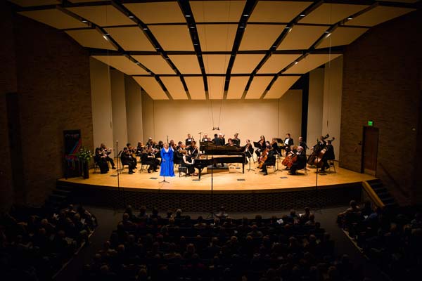wide shot of orchestra and singer