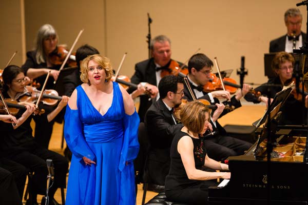 woman in blue dress singing with orchestra
