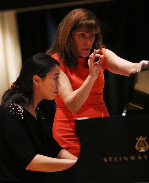 Lori Sims giving notes to a student on the piano