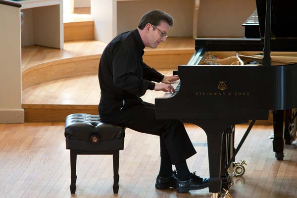 Llyr Williams in black outfit playing steinway