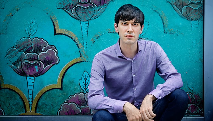 portrait of glenn zaleski in front of a bright blue wall
