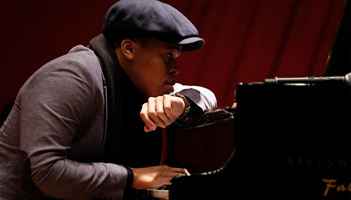 portrait of isaiah thompson resting at a piano