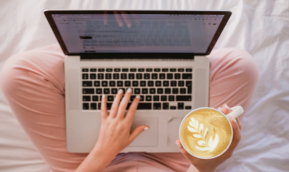 woman using laptop while drinking coffee