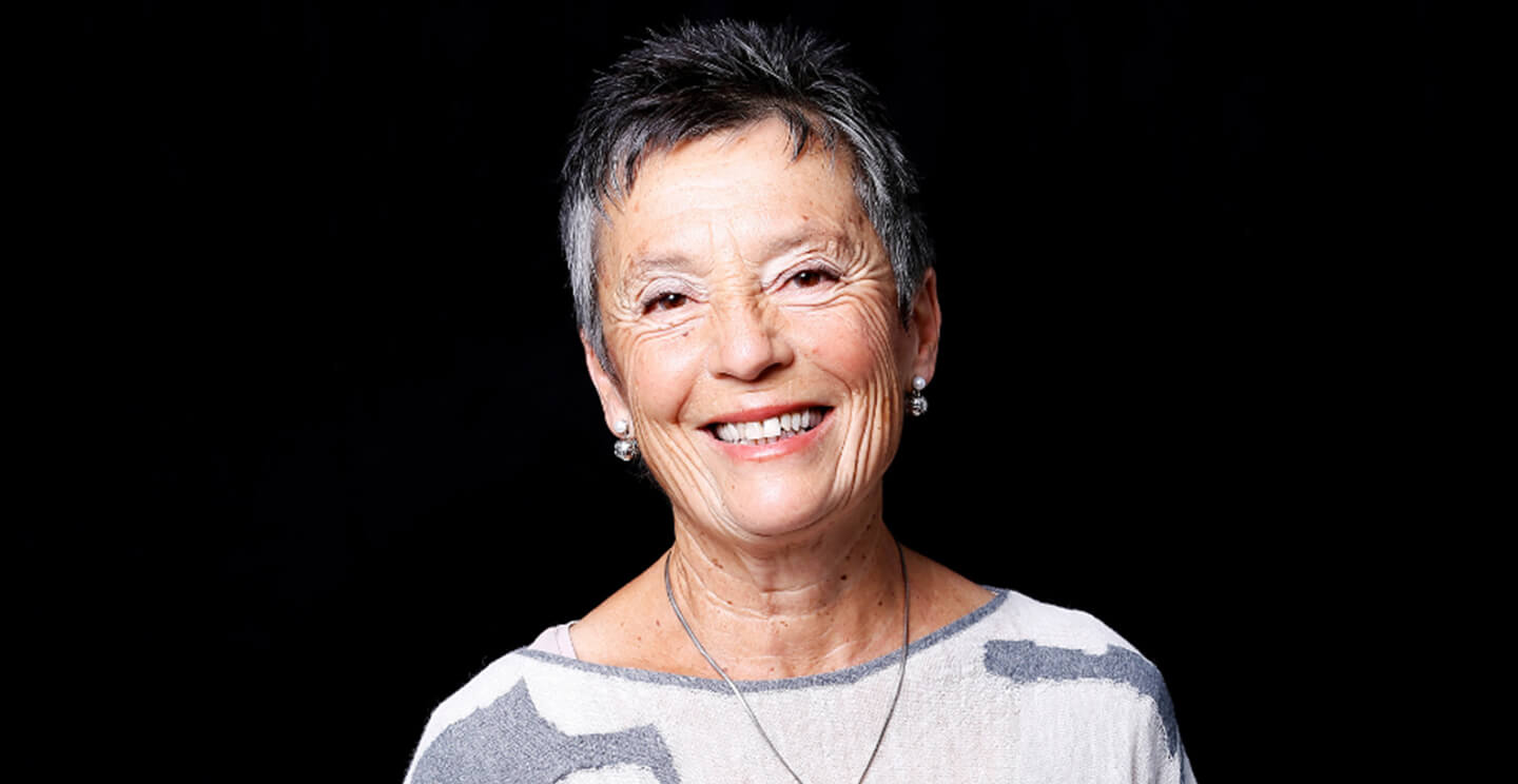 maria joao pires smiles for a portrait on a black background