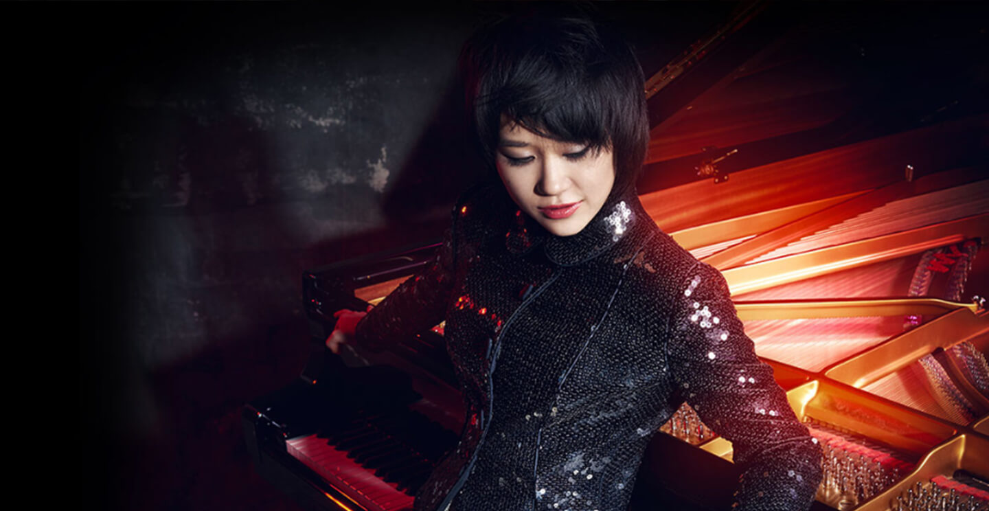 yuja wang poses with a dramatic red and black background