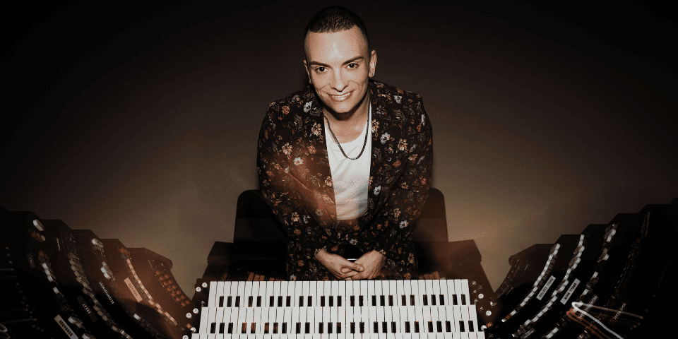 Cameron Carpenter posing by a piano