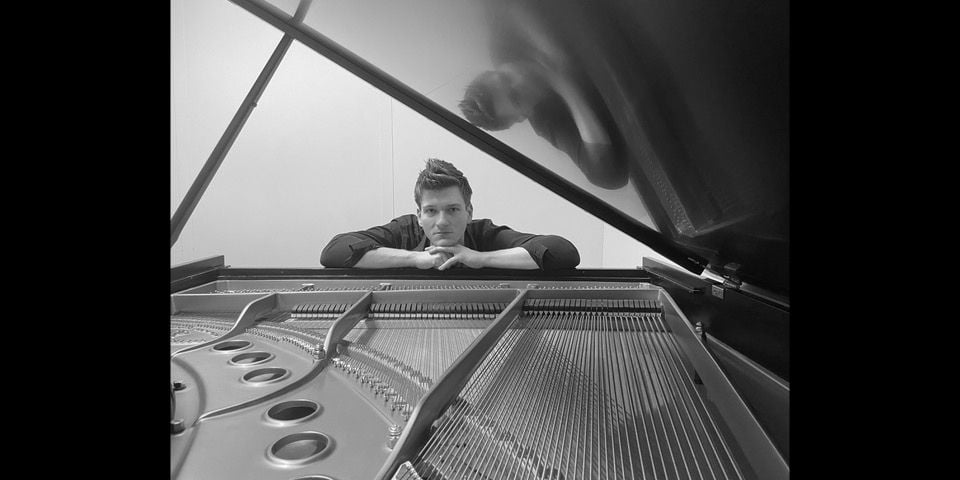 Bill Cessna posing by a piano